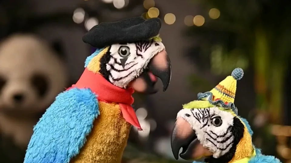Two colorful parrot characters posed as a live commentary duo